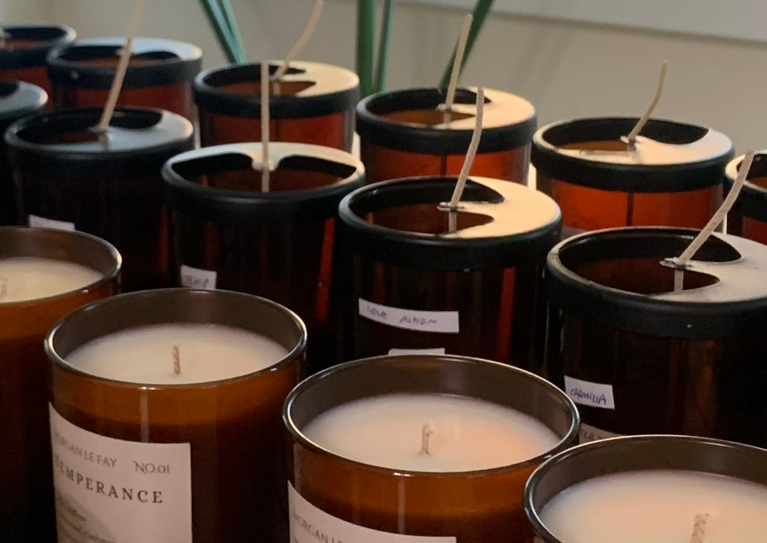 Rows of candles and freshly-wicked candle jars.
