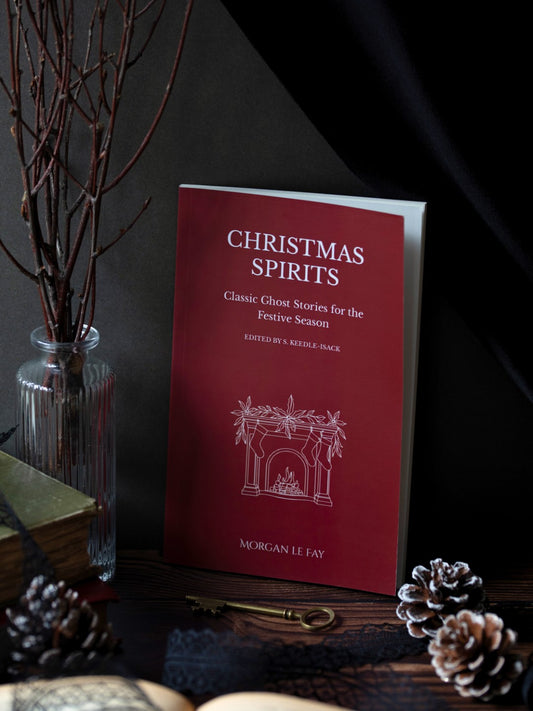 Book titled 'Christmas Spirits' on a dark surface with decorative elements.