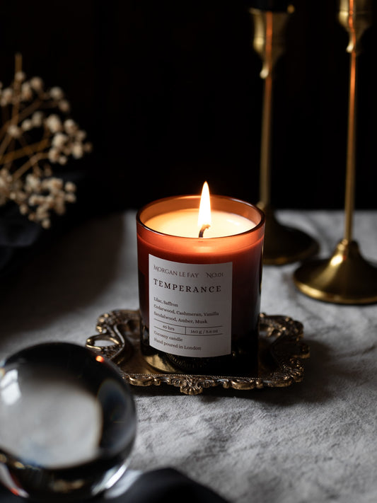 Candle labeled 'Temperance' on a decorative tray with a dark background